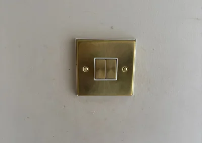 A brass-finish double light switch.