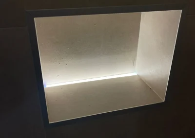 Concealed lighting highlights a recessed wall niche.