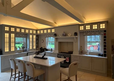 Warm concealed lighting highlights the kitchen ceiling and cabinets.