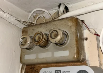 An older ceramic fuse board beside the electricity meter.